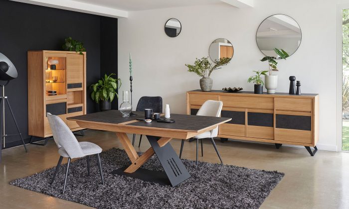 Photo d'une salle à manger avec une collection comportant une table de repas, une enfilade et une vitrine. Les meubles présente des finitions chêne teinte ton brut brossé et des éléments céramique marbré gris.